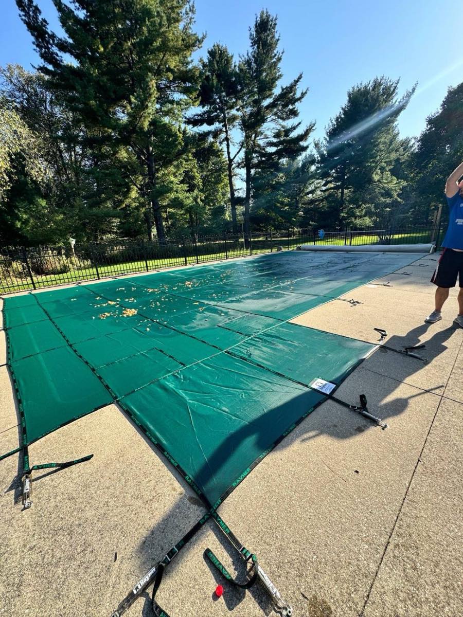 Heartland technician installing a winter safety cover on a Lake Country pool